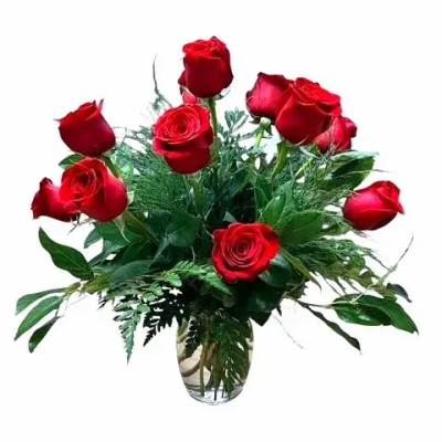 Red roses arranged in a clear glass vase with greenery
