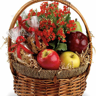 Gift basket with red flowers, apples, pears, and wrapped snacks