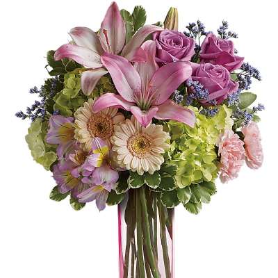 Pink lilies, roses, and daisies in a clear glass vase