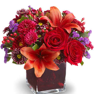 Red roses and orange lilies in a square glass vase