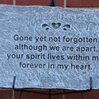 Memorial stone plaque with an engraved sympathy message on a stand