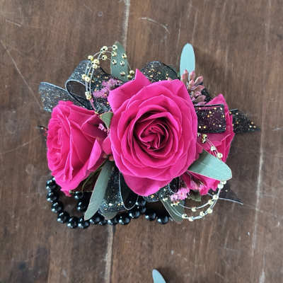Bright pink roses with black ribbon and bead accents