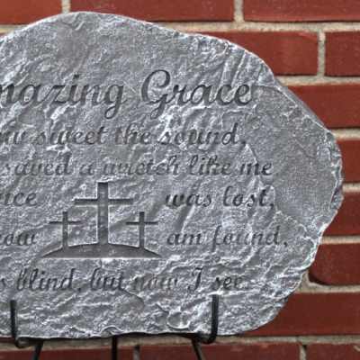 Engraved gray memorial stone with a cross design and poem text