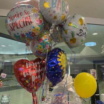 Cluster of birthday and baby-themed foil balloons indoors
