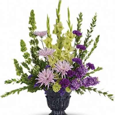 Purple and green floral arrangement in a black urn vase