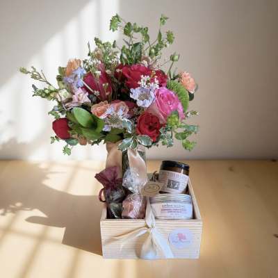 Mixed bouquet in a wooden gift box with candles and bath items