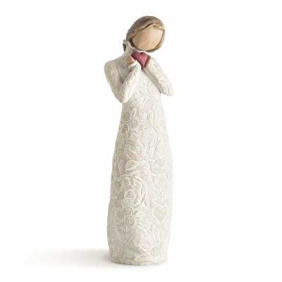 Cream-colored figurine of a girl holding a pink heart