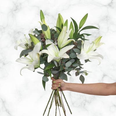 Handheld bouquet of white lilies with eucalyptus foliage