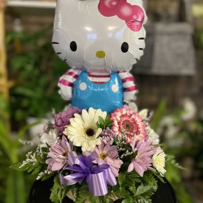 Hello Kitty balloon above a pastel flower arrangement
