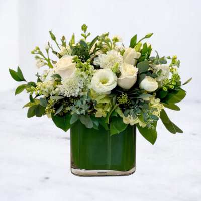 White floral arrangement in a green glass vase