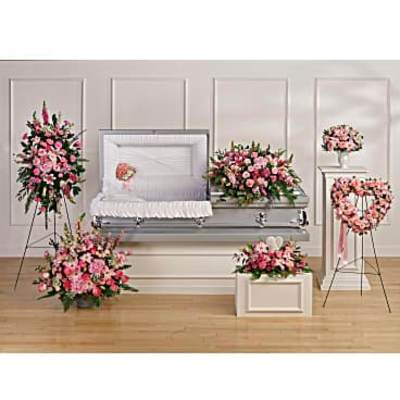Pink and white funeral floral set with casket spray, standing sprays, wreath and arrangements around a silver casket