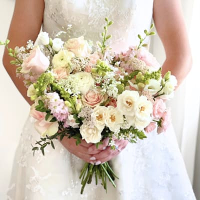 Bride holding a pastel bouquet of pink and white flowers