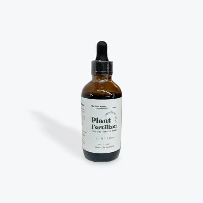 Amber dropper bottle of plant fertilizer on a white background