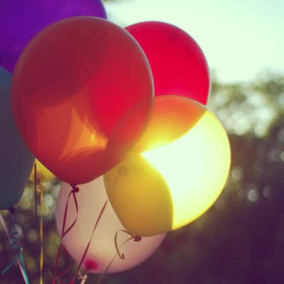 Cluster of colorful balloons tied together outdoors