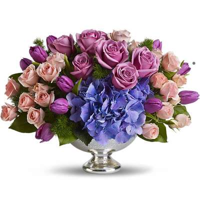 Lavender and pink roses with blue hydrangeas in a silver pedestal bowl