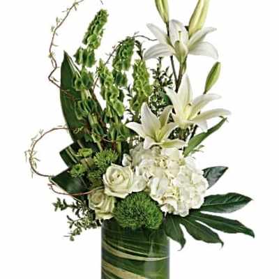 White lilies and roses in a green glass vase
