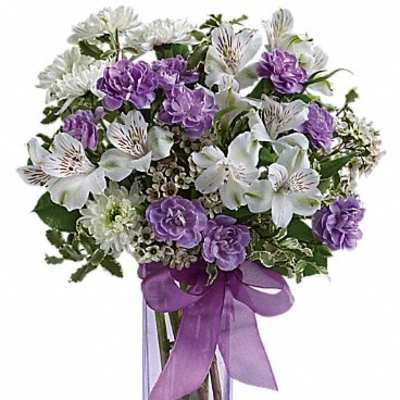 Purple and white bouquet in a clear glass vase with a ribbon