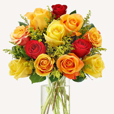 Bouquet of red, yellow, and orange roses in a clear glass vase