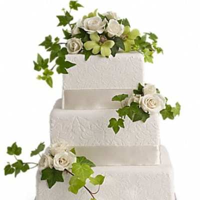 Three-tier white cake decorated with white roses and ivy