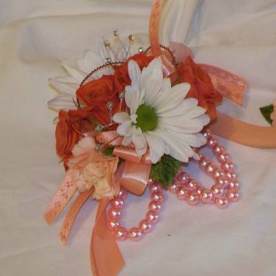 Small corsage with white daisies, peach roses, and pink ribbon beads