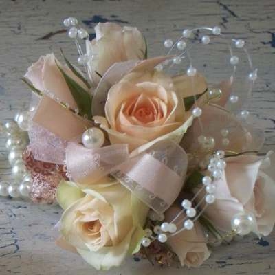 Small bouquet of pale peach roses with pearl accents and ribbon