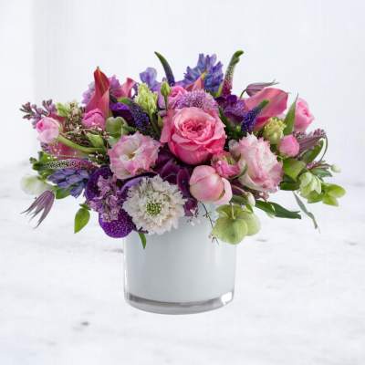 Pink and purple mixed flower arrangement in a clear glass vase