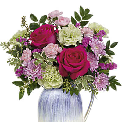 Mixed bouquet of pink roses, green carnations, and lavender mums in a blue and white ceramic pitcher.