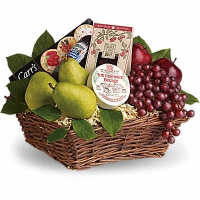 Fruit and snack gift basket in a wicker tray with pears, grapes, and packaged treats
