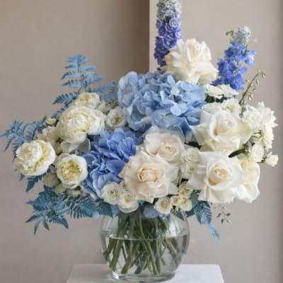 Blue and white floral arrangement in a clear glass vase