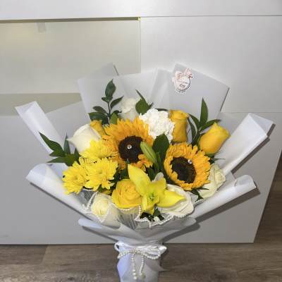 Beautiful and elegant arrangement with a glass base and mixed yellow flowers