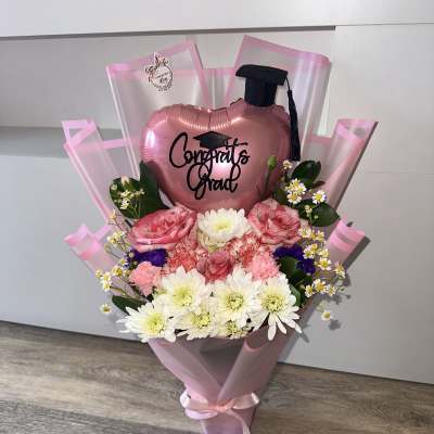 Graduation detail with balloon, graduation cap, and natural flowers