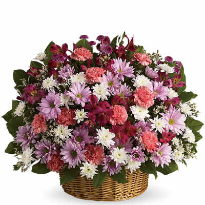 Mixed basket of pink carnations and lavender and white daisies in a round woven basket