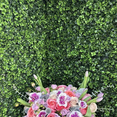 Pink and lavender rose bouquet with orchids in a gold vase