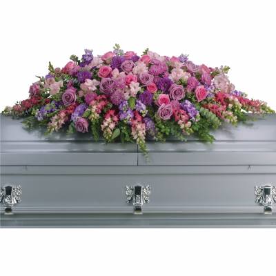 Pink and purple floral spray on a silver casket