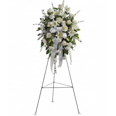 White floral standing spray on a black easel with ribbon