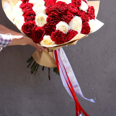 Bouquet of red and white roses wrapped in brown paper