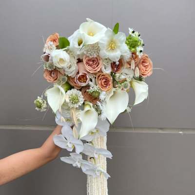 Handheld bouquet with white calla lilies, peach roses, and trailing white orchids