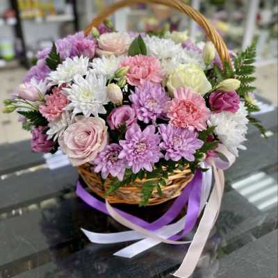 Basket of pink, white, and lavender flowers with ribbon streamers