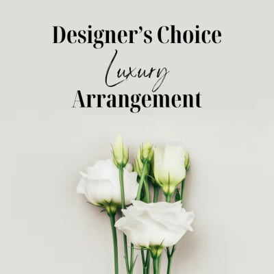 White roses arranged beneath the words "Designer’s Choice Luxury Arrangement"