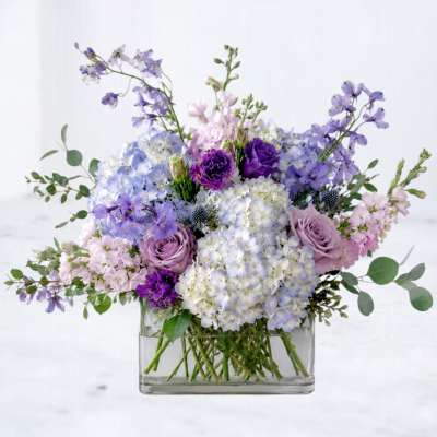 Lavender and blue bouquet in a clear rectangular vase