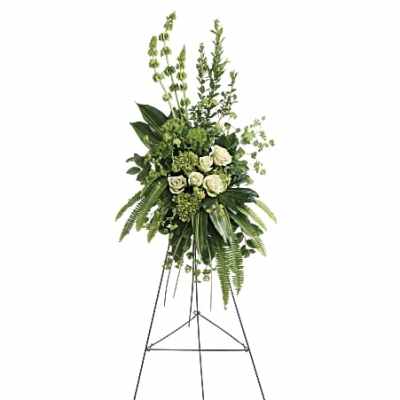 Tall green and white standing spray with roses and Bells of Ireland on a black metal easel