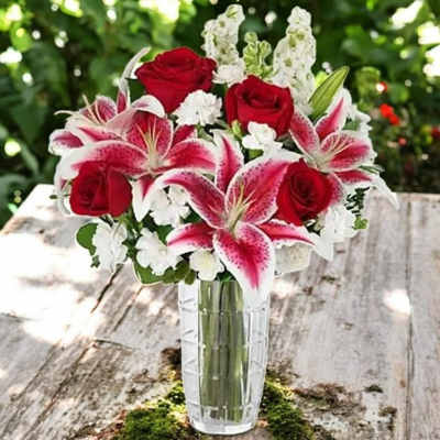 Red roses and pink lilies in a clear glass vase