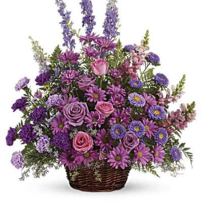 Lavender and purple roses, daisies, and mixed flowers arranged in a wicker basket