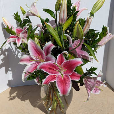 Pink stargazer lilies arranged in a clear glass vase