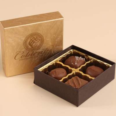 Small box of assorted milk chocolates in an open brown and gold gift box