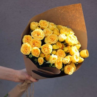 Bouquet of yellow roses wrapped in brown paper