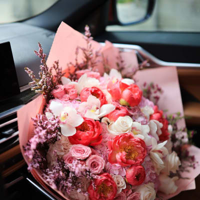 Pink and white bouquet with roses and peonies wrapped in pink paper