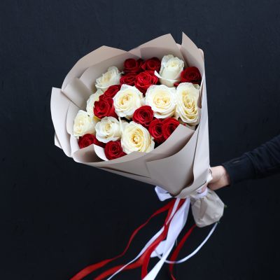 Bouquet of red and white roses wrapped in beige paper with red and white ribbons