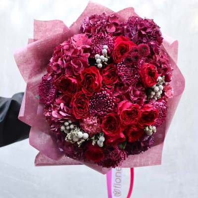 Bouquet of red and magenta flowers wrapped in pink paper