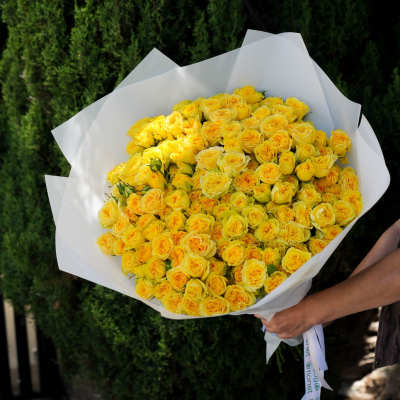 Bouquet of yellow roses wrapped in white paper